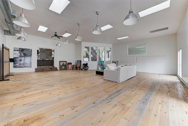 living room with plenty of natural light, a skylight, and hardwood / wood-style floors