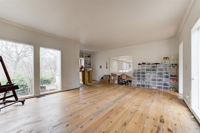 interior space featuring visible vents, hardwood / wood-style floors, and crown molding