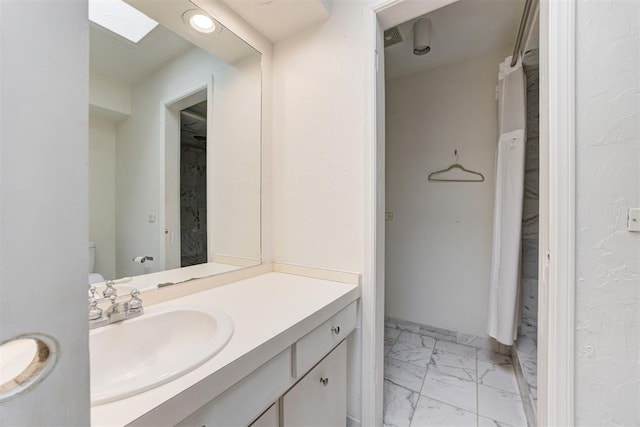 bathroom featuring marble finish floor and vanity