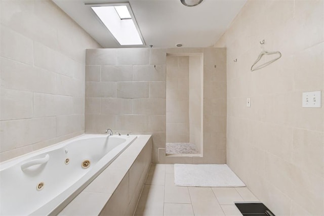 bathroom with tile patterned flooring, tile walls, a tile shower, and a whirlpool tub