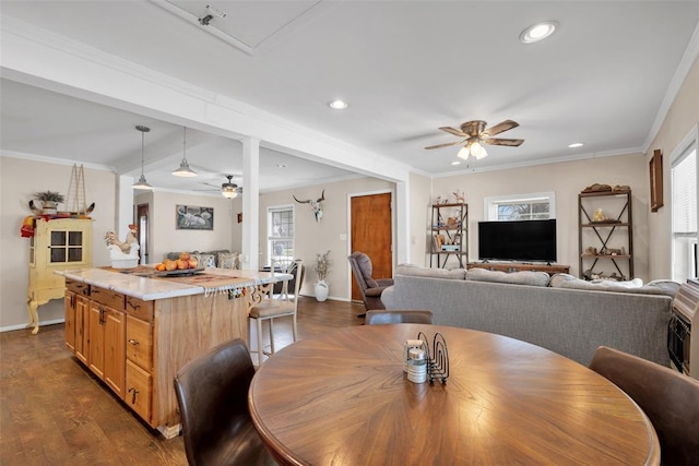 dining space with dark wood finished floors, ornamental molding, plenty of natural light, and ceiling fan