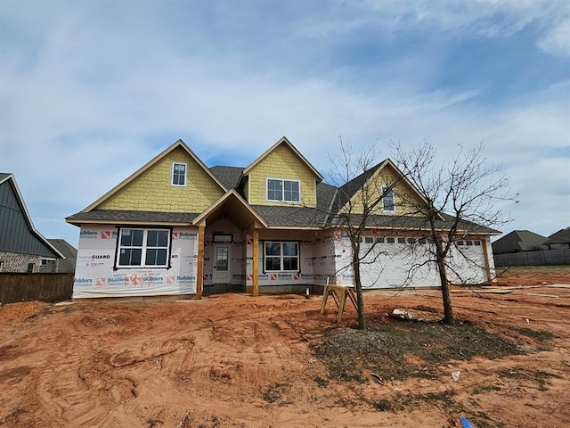 property in mid-construction with an attached garage and fence