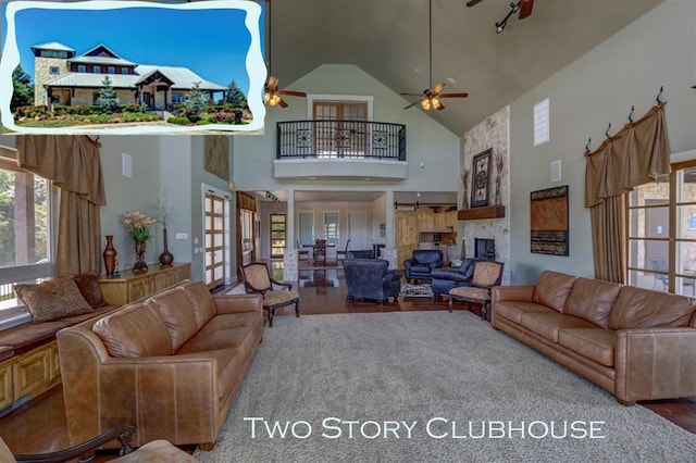 living area with a stone fireplace, a towering ceiling, and ceiling fan