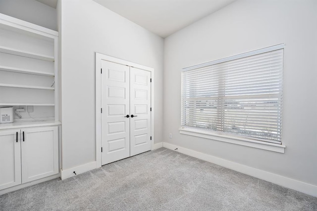 unfurnished bedroom with light carpet and baseboards