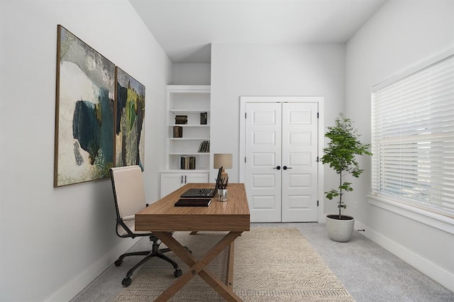 home office featuring light carpet and baseboards