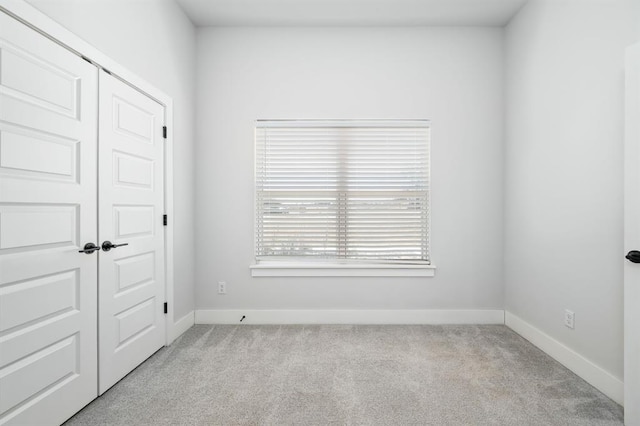 unfurnished bedroom with a closet, carpet flooring, and baseboards