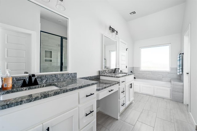 bathroom featuring visible vents, lofted ceiling, a garden tub, a stall shower, and vanity