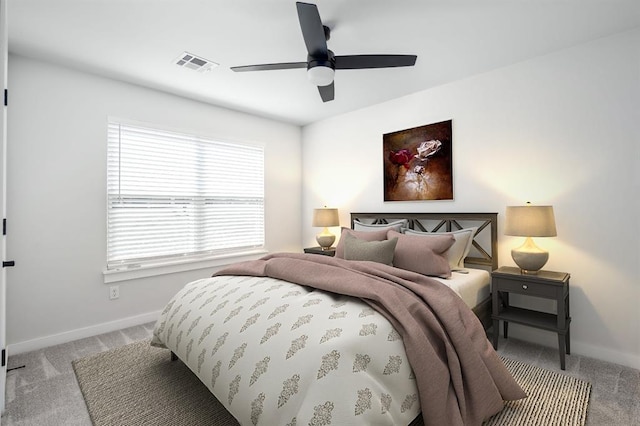 carpeted bedroom featuring baseboards, visible vents, and ceiling fan