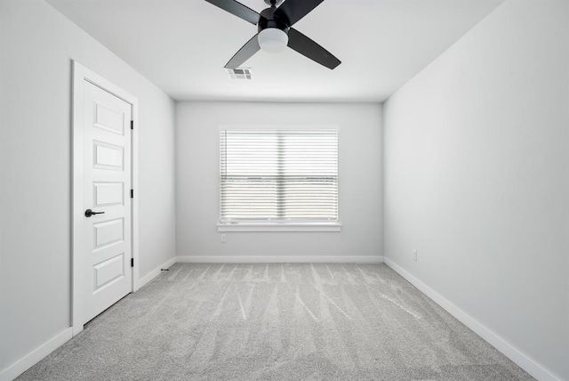 unfurnished room with ceiling fan, visible vents, baseboards, and light carpet