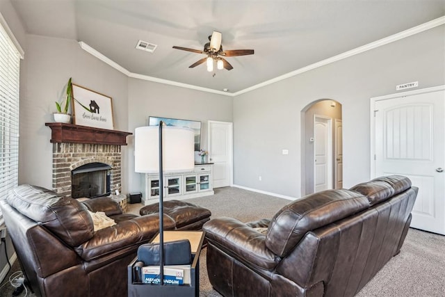 living room featuring visible vents, crown molding, carpet floors, a fireplace, and arched walkways