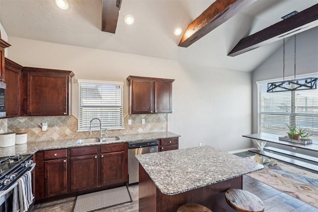 kitchen with gas stove, light wood-style flooring, vaulted ceiling with beams, a sink, and dishwasher