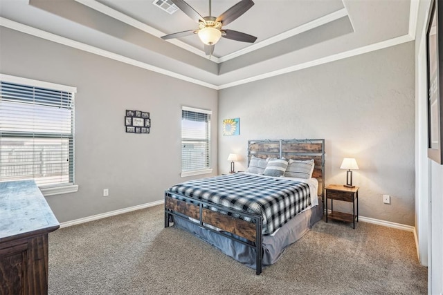 bedroom with a tray ceiling, carpet floors, and visible vents