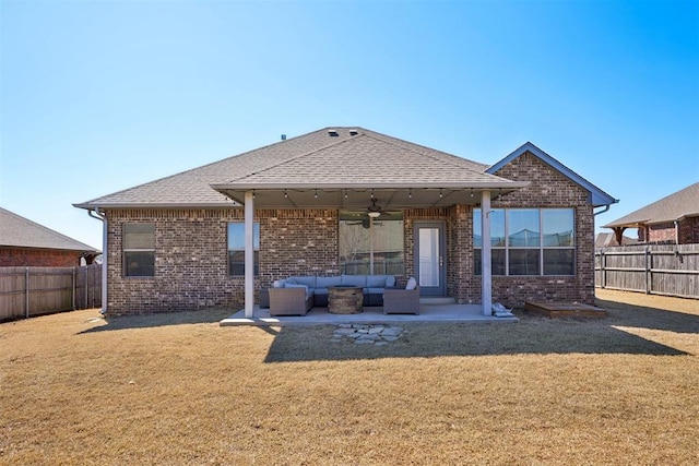 rear view of house with an outdoor living space, a yard, a fenced backyard, ceiling fan, and a patio area