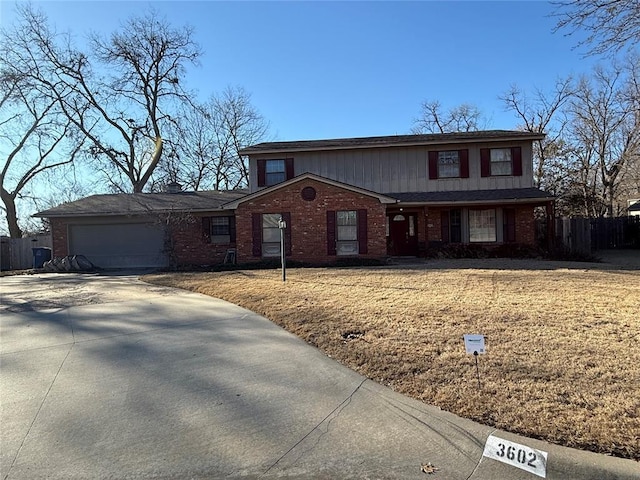 traditional-style house featuring fence, concrete driveway, a front yard, a garage, and brick siding