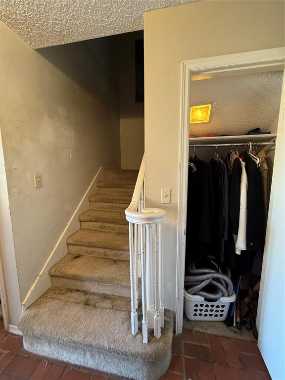 stairway featuring brick floor