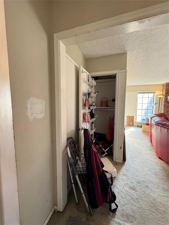 hall featuring a textured ceiling and carpet