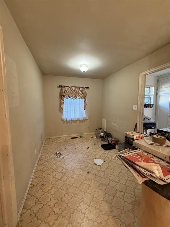 empty room with a wealth of natural light and baseboards