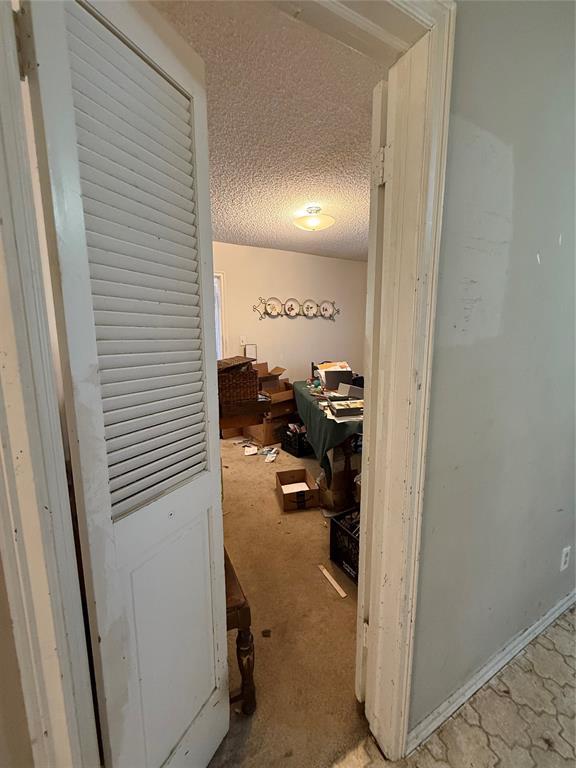 hall featuring a textured ceiling