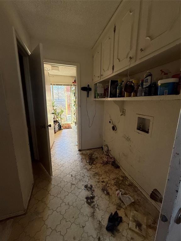 clothes washing area with hookup for a gas dryer, cabinet space, a textured ceiling, and hookup for a washing machine