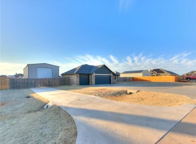 ranch-style house featuring stone siding, driveway, and fence