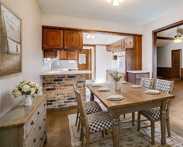 dining area featuring a ceiling fan and dark wood-style flooring