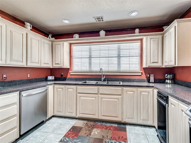 kitchen featuring stainless steel dishwasher, light tile patterned floors, visible vents, and a sink