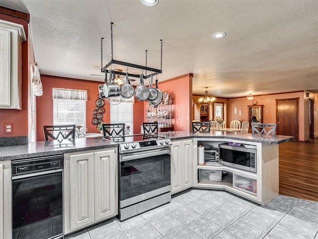 kitchen featuring light tile patterned floors, stainless steel appliances, a textured ceiling, white cabinetry, and crown molding