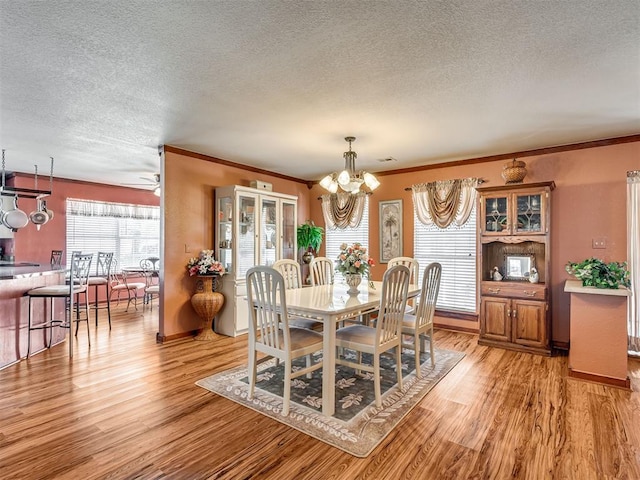 dining area featuring crown molding and light wood finished floors