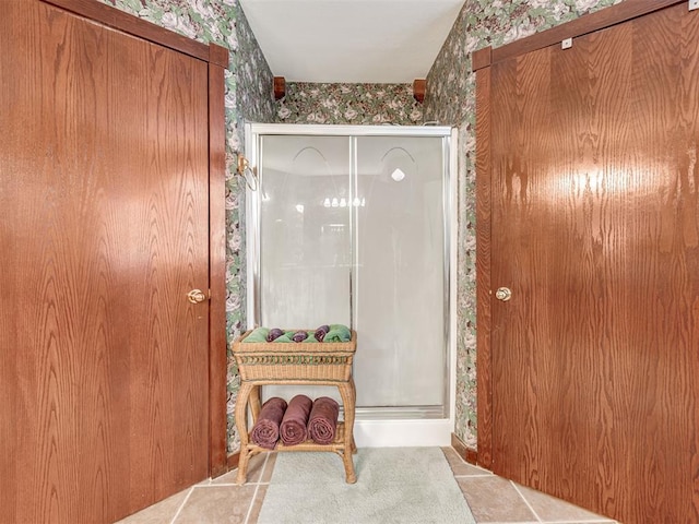 bathroom with tile patterned floors, a shower stall, and wallpapered walls