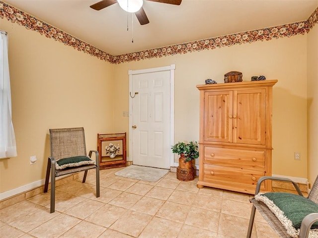 sitting room featuring light tile patterned flooring, baseboards, and ceiling fan