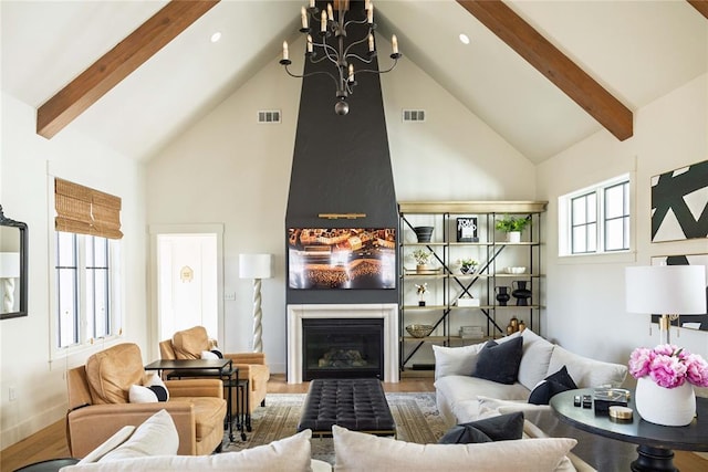 living room with visible vents, beam ceiling, and high vaulted ceiling