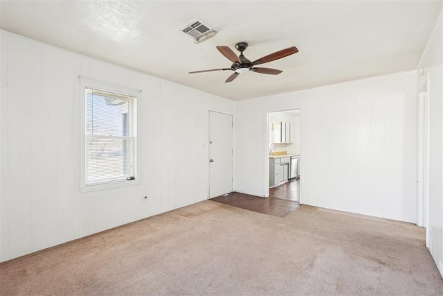 spare room with a sink, visible vents, a ceiling fan, and carpet flooring