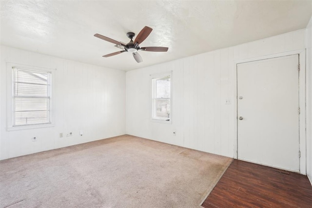 carpeted spare room with a ceiling fan