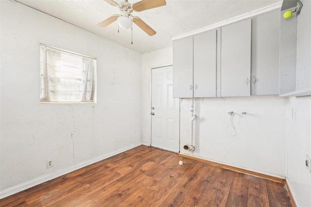 clothes washing area featuring ceiling fan, baseboards, and wood finished floors