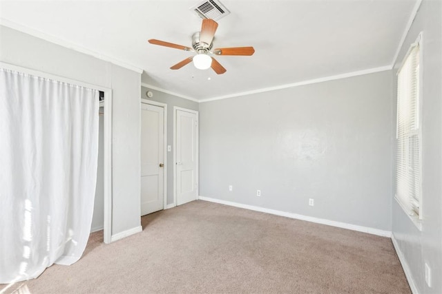 unfurnished bedroom featuring carpet flooring, baseboards, visible vents, and ornamental molding