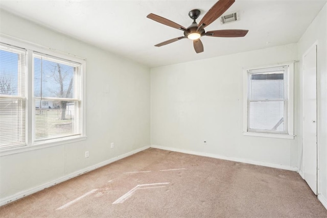 empty room with visible vents, a ceiling fan, baseboards, and carpet floors