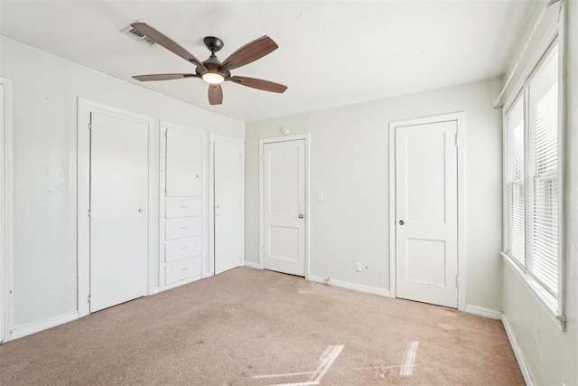 unfurnished bedroom with visible vents, baseboards, ceiling fan, and carpet flooring