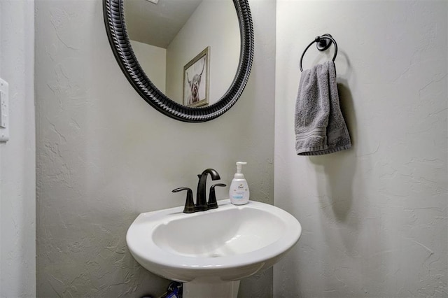 bathroom with a sink and a textured wall