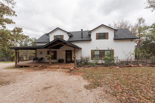 modern inspired farmhouse featuring a shingled roof and fence