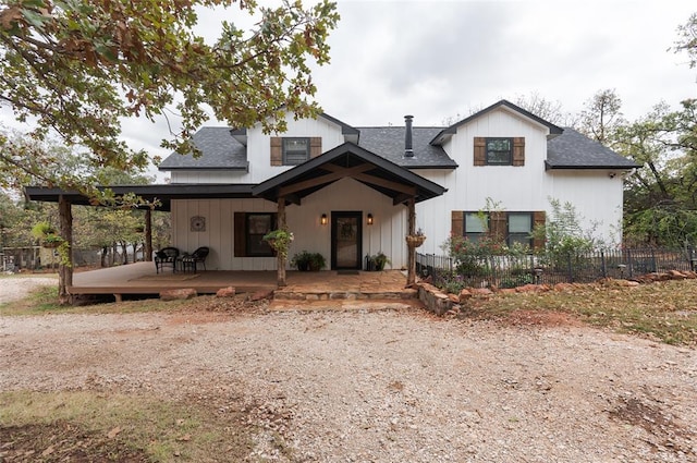 view of front of house featuring fence and roof with shingles