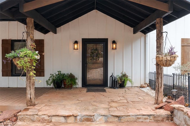 property entrance featuring a patio, fence, and board and batten siding