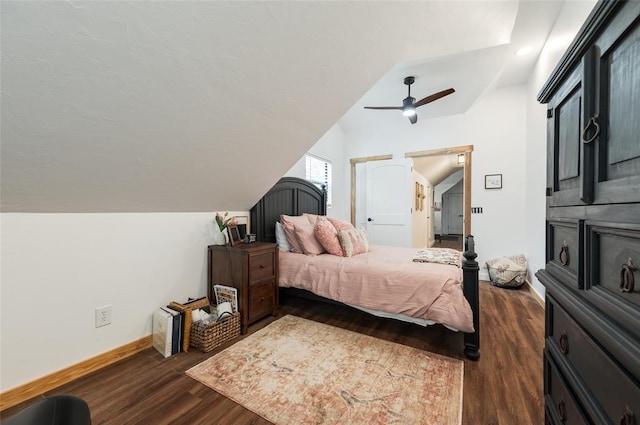 bedroom featuring baseboards, lofted ceiling, dark wood-style floors, and a ceiling fan