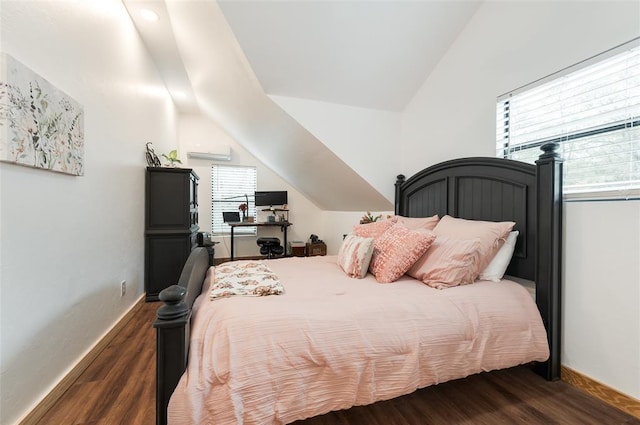 bedroom with baseboards, lofted ceiling, and wood finished floors