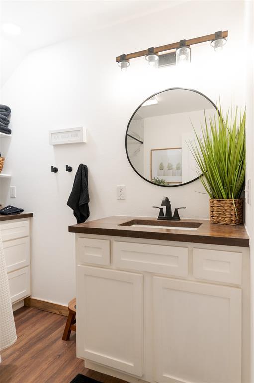 bathroom featuring vanity, wood finished floors, and baseboards