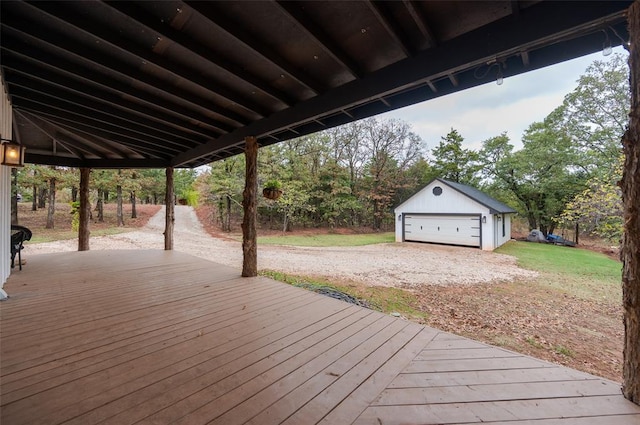 wooden terrace featuring a garage and an outbuilding