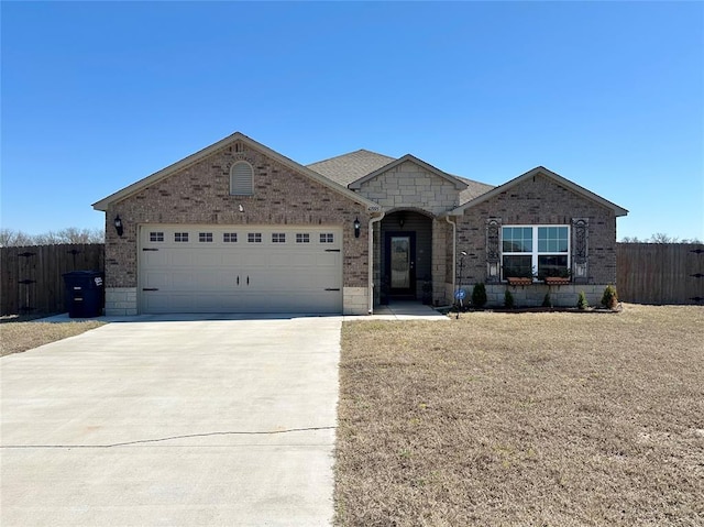 view of front of property featuring driveway, brick siding, an attached garage, and fence