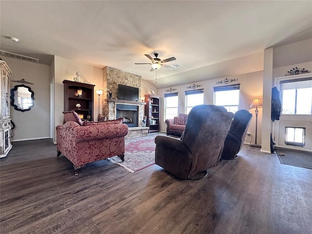 living room featuring a wealth of natural light, a ceiling fan, dark wood finished floors, and a fireplace