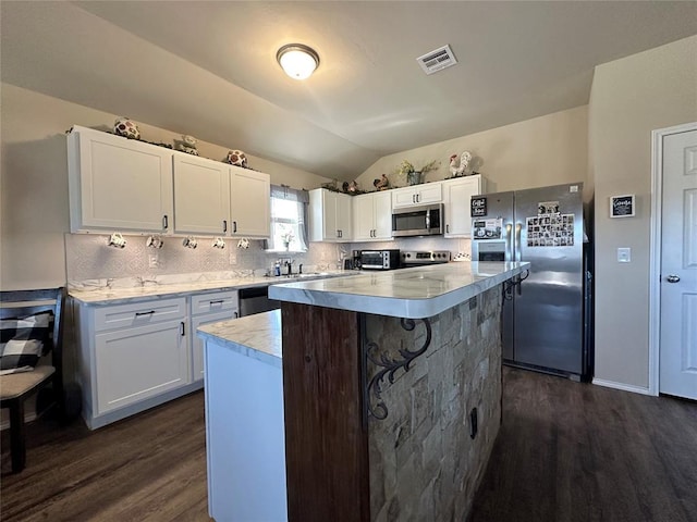 kitchen with visible vents, lofted ceiling, stainless steel appliances, light countertops, and backsplash