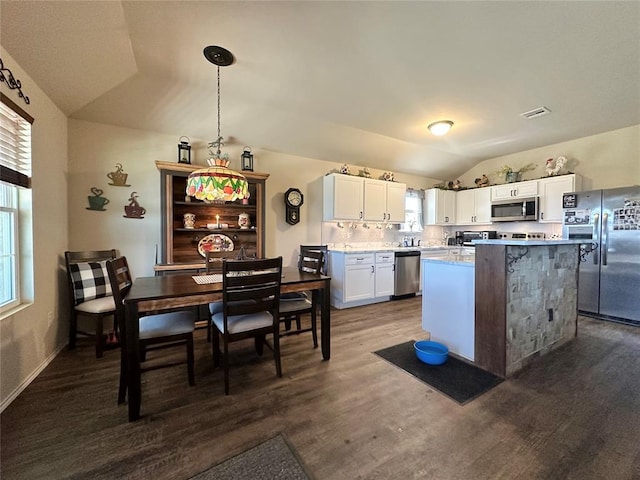 kitchen with lofted ceiling, decorative backsplash, light countertops, white cabinets, and appliances with stainless steel finishes