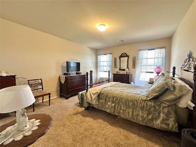 bedroom with multiple windows, light colored carpet, visible vents, and baseboards